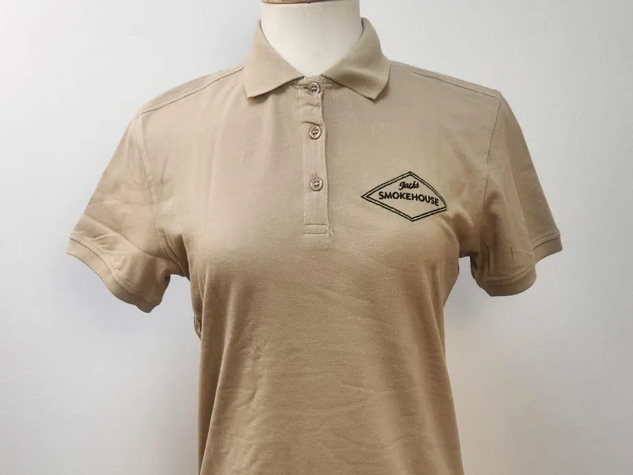 Polo beige con logotipo bordado en el pecho, sobre maniquí