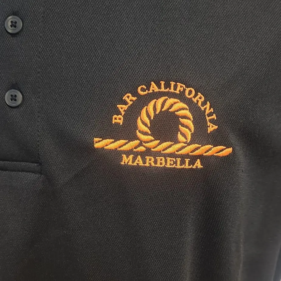 Polo negro con bordado de logotipo en hilo naranja en el pecho