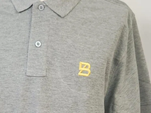 Polo gris con logotipo bordado en el pecho izquierdo