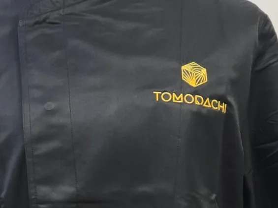 Prenda con logotipo bordado en pecho, sobre la botonadura
