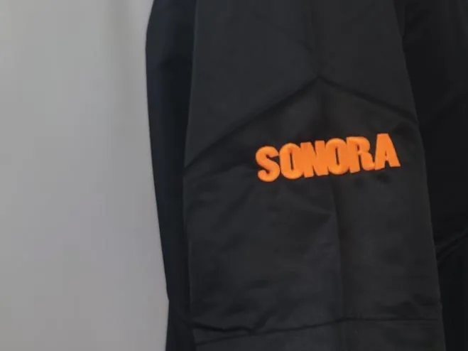Prenda con logotipo bordado en bolsillo de manga