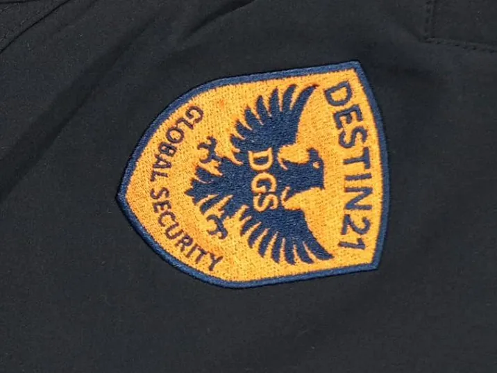 Escudo bordado a todo color junto al bolsillo de una chaqueta negra